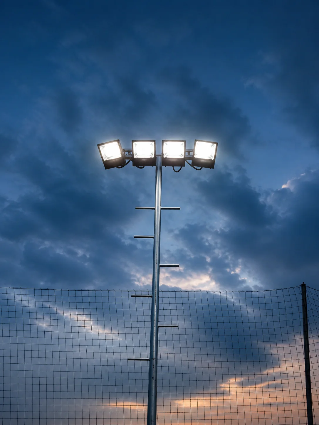 Lámparas para canchas de fútbol con reflectores LED en poste y malla perimetral
