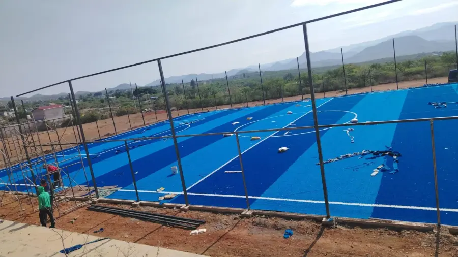Cuánto sale poner pasto sintético con líneas de juego insertadas en una cancha azul con malla