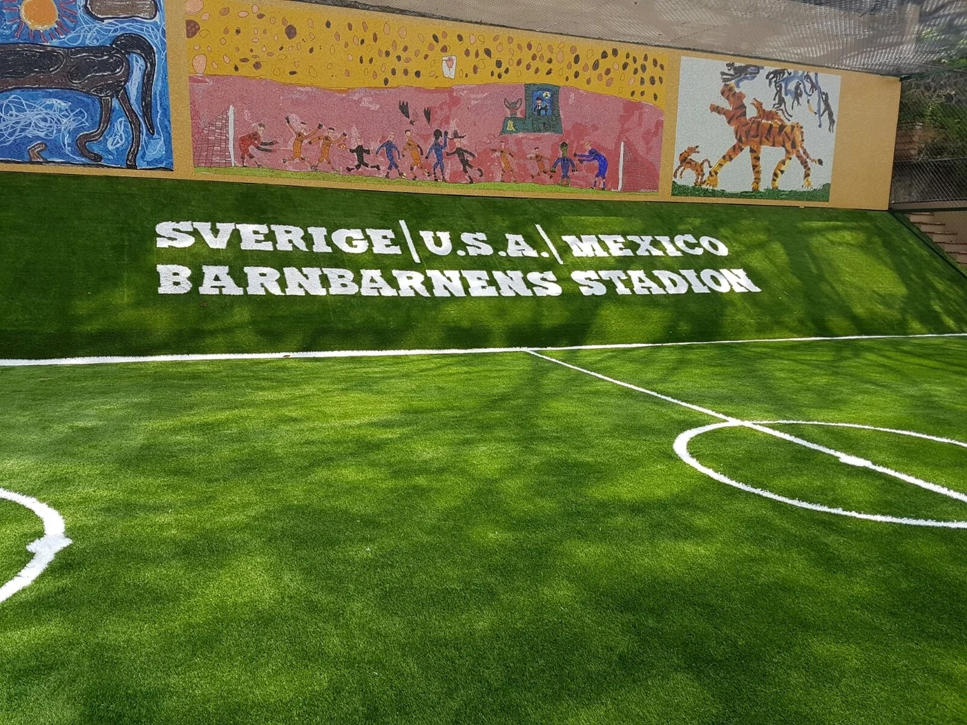 Nombre Sverige USA México Barnbarnens Stadion insertado en pasto sintético en una cancha techada con mural en Cuernavaca, Morelos