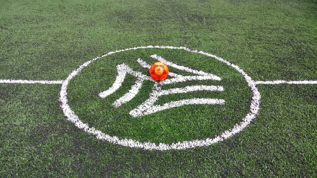 Logotipo circular de un torneo de fútbol con un balón al centro insertado en pasto sintético en el círculo central