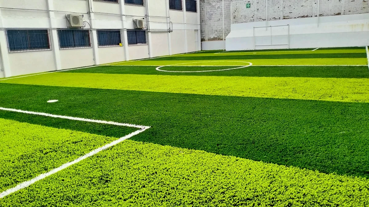 Cancha de fútbol 5 con pasto sintético en Colegio Diego Rivera, Tuxtla Gutiérrez, Chiapas: la cancha desde la línea lateral