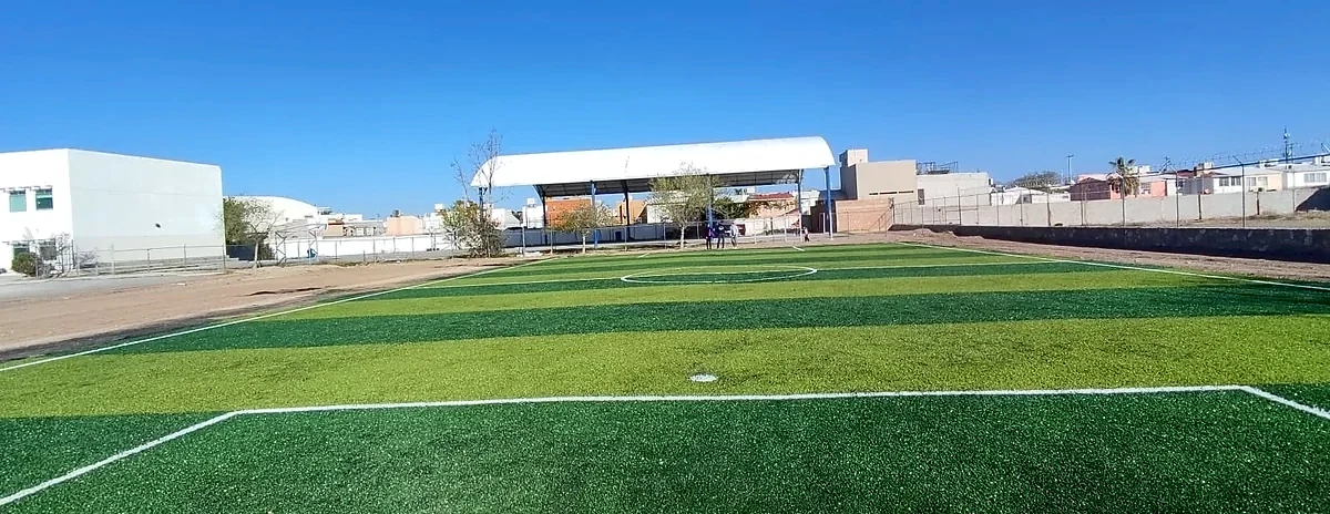 Cancha de fútbol 7 con pasto sintético en Instituto Visión, Ciudad Juárez, Chihuahua: la cancha desde la línea lateral