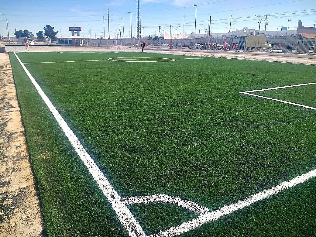 Cancha de fútbol 7 con pasto sintético en Planta Nexteer, Ciudad Juárez, Chihuahua: la cancha desde la línea lateral