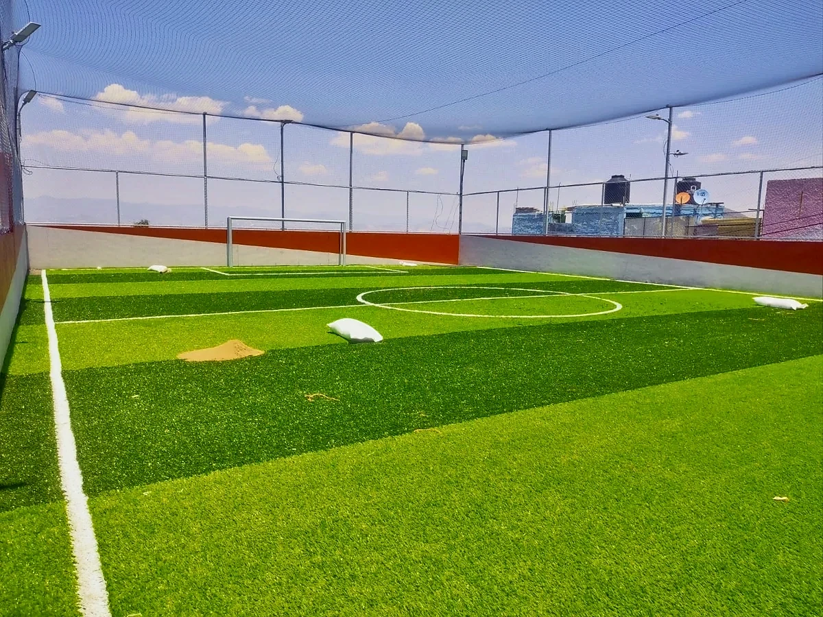 Cancha de fútbol 7 con pasto sintético en Cancha la Cande, Gustavo A. Madero, Ciudad de México: la cancha desde la línea lateral