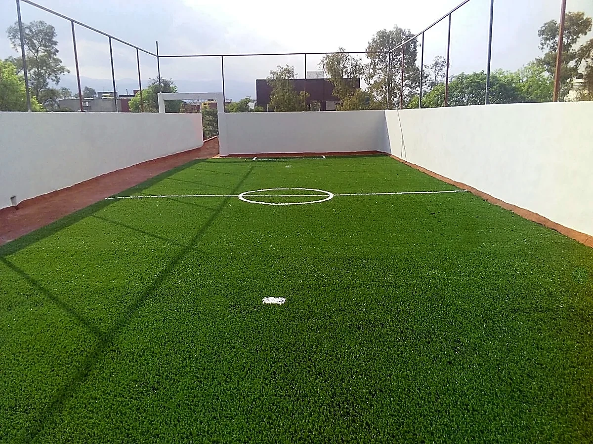 Cancha de fútbol 7 con pasto sintético en Colegio Aztlán, Tlalpan, Ciudad de México: líneas de juego insertadas en el mismo pasto