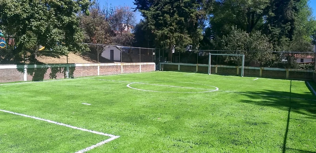 Cancha de fútbol 7 con pasto sintético en Niño IAP, Magdalena Contreras, Ciudad de México: líneas de juego insertadas en el mismo pasto