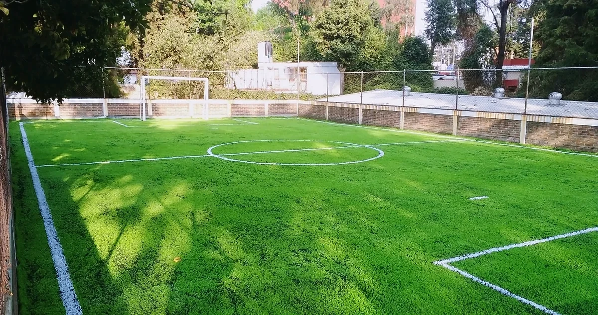 Cancha de fútbol 7 con pasto sintético en Niño IAP, Magdalena Contreras, Ciudad de México: pasto sintético deportivo recién cepillado