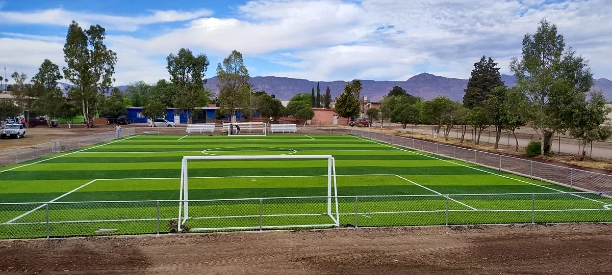 Cancha de fútbol 7 con pasto sintético en Escuela Primaria 20 de Noviembre, José Guadalupe Aguilera, Durango: la cancha desde la línea lateral