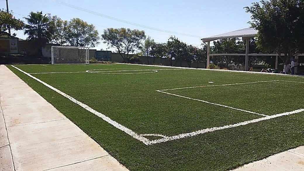 Cancha de fútbol 5 con pasto sintético en CBT Cuauhtinchán, Malinalco, Estado de México: la cancha desde la línea lateral
