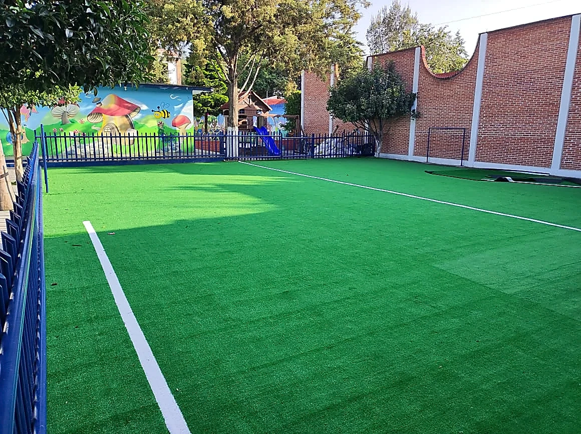 Cancha de fútbol 5 con pasto sintético en Colegio Yamier, San Andrés Chiautla, Estado de México: la cancha desde la línea lateral