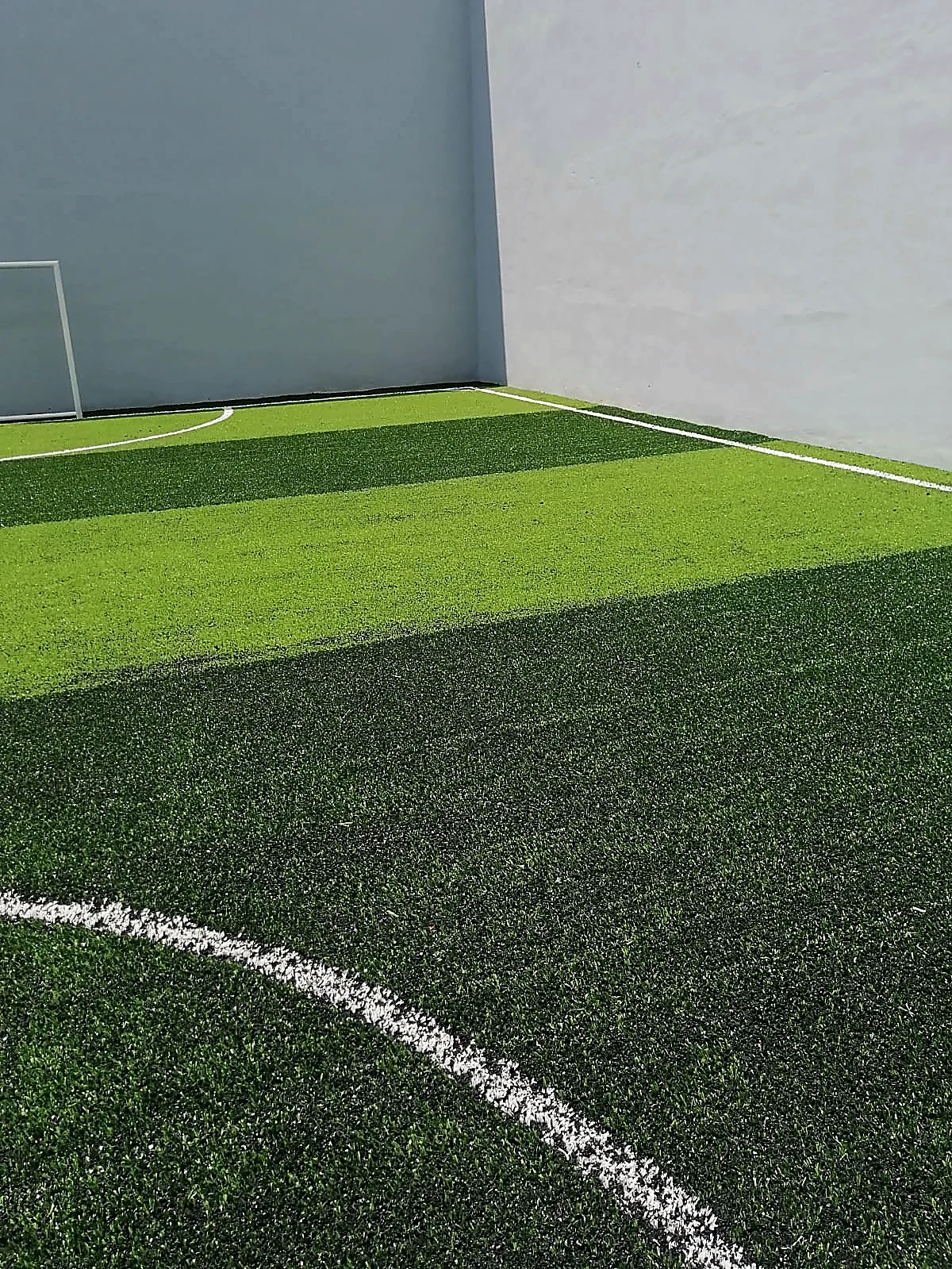 Cancha de fútbol 5 con pasto sintético en Empresa la Moderna, Toluca, Estado de México: la cancha desde la línea lateral