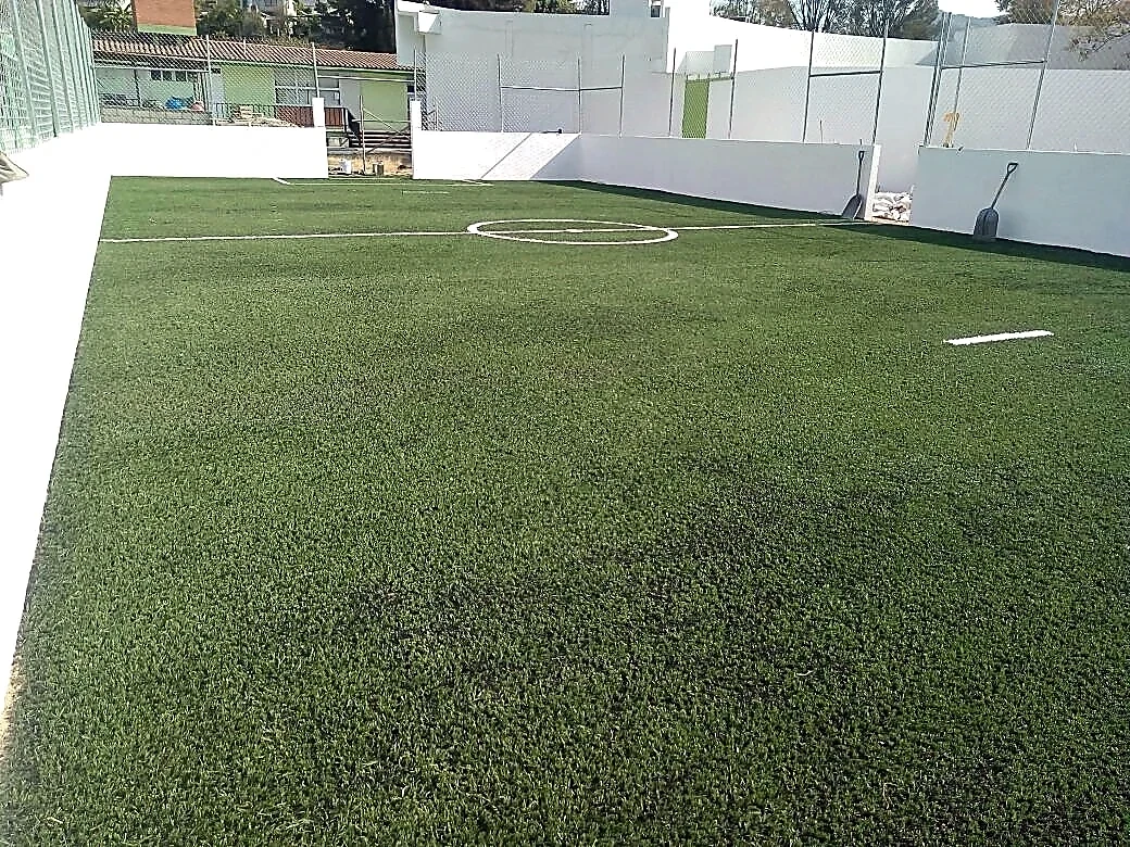 Cancha de fútbol 5 con pasto sintético en Escuela Primaria Benito Juárez, Zumpahuacán, Estado de México: pasto sintético deportivo recién cepillado