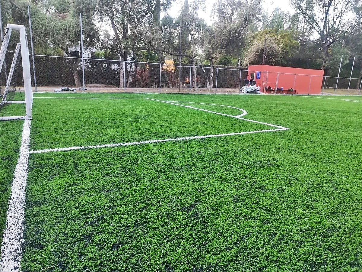 Cancha de fútbol 7 con pasto sintético en Hacienda San Miguel Country Club, Atizapán, Estado de México: pasto sintético deportivo recién cepillado