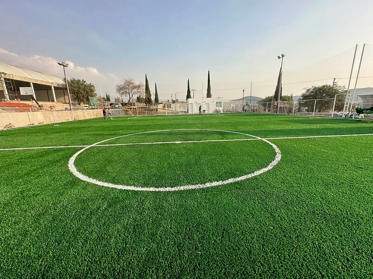 Cancha de fútbol 7 con pasto sintético en Parque Paseo de Coxtitlán, Chicoloapan, Estado de México: la cancha desde la línea lateral