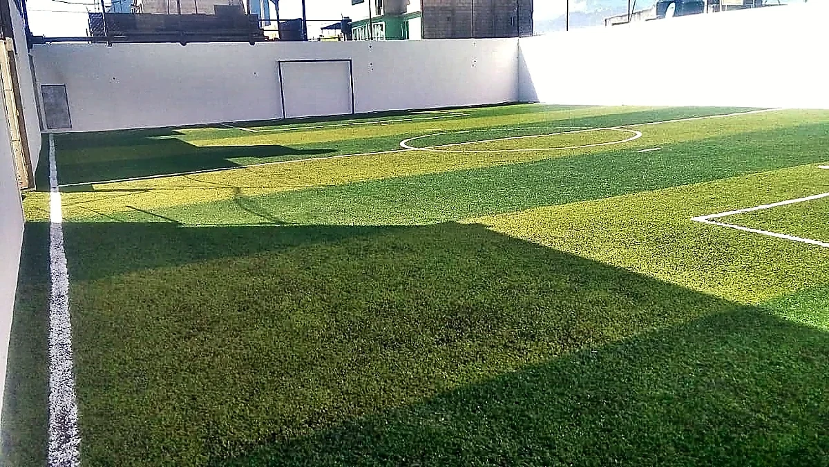 Cancha de fútbol rápido con pasto sintético en Cancha Deportiva Millán, Toluca, Estado de México: líneas de juego insertadas en el pasto