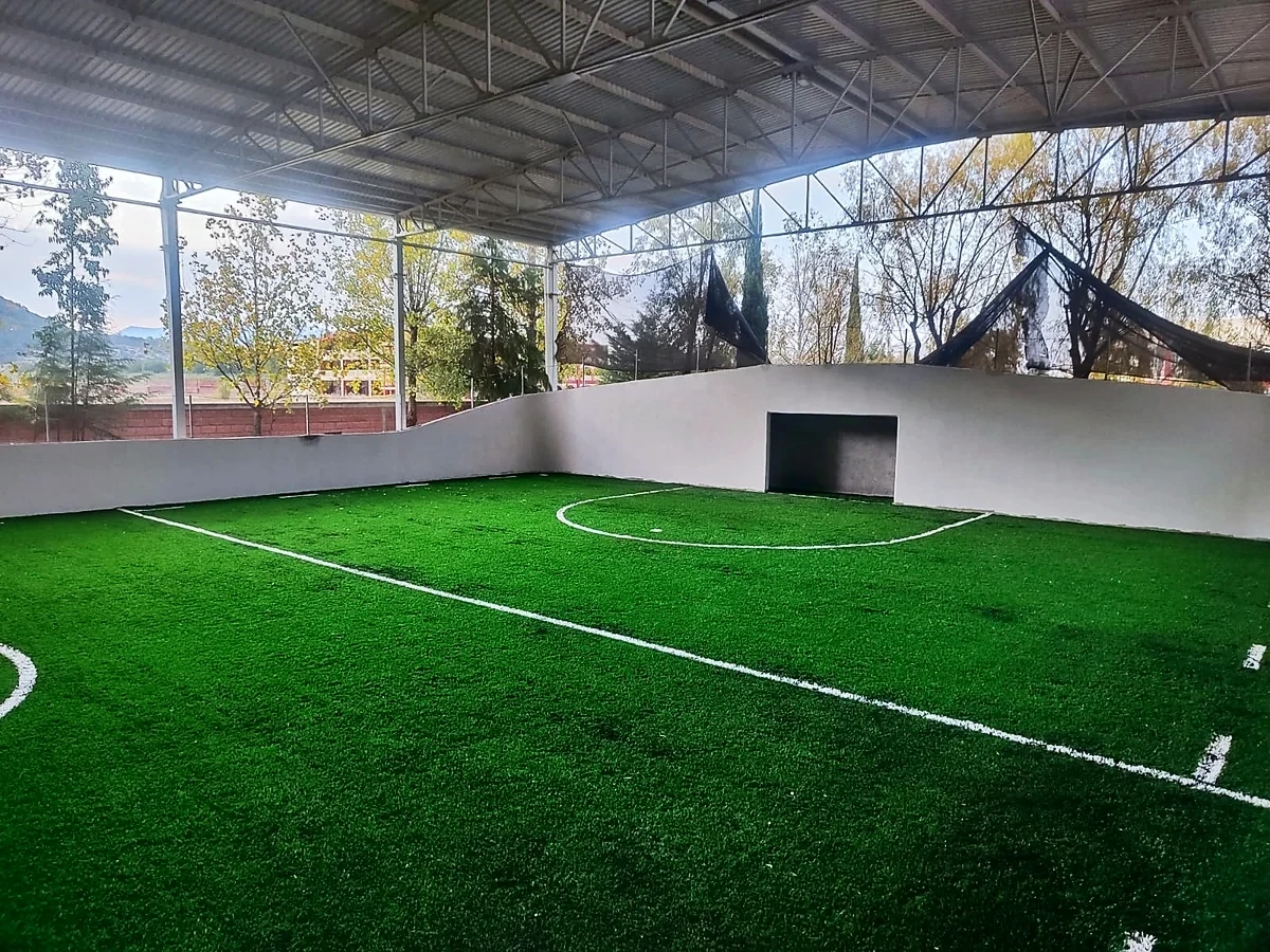 Cancha de fútbol rápido con pasto sintético en Unidad Deportiva la Cortina, Temascalcingo, Estado de México: pasto sintético deportivo recién cepillado