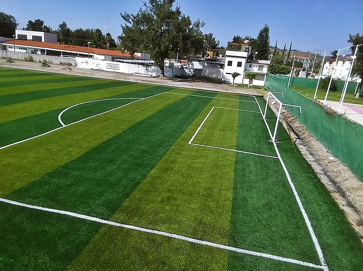 Cancha de fútbol soccer con pasto sintético en Cancha El Salitre, Ixtapan de la Sal, Estado de México: la cancha desdel fondo