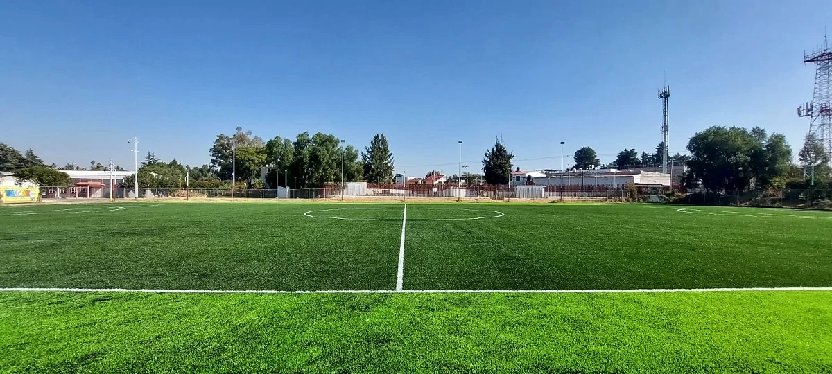 Cancha de fútbol soccer con pasto sintético en Parque El Cooperativo, Texcoco, Estado de México: la cancha desde la línea lateral
