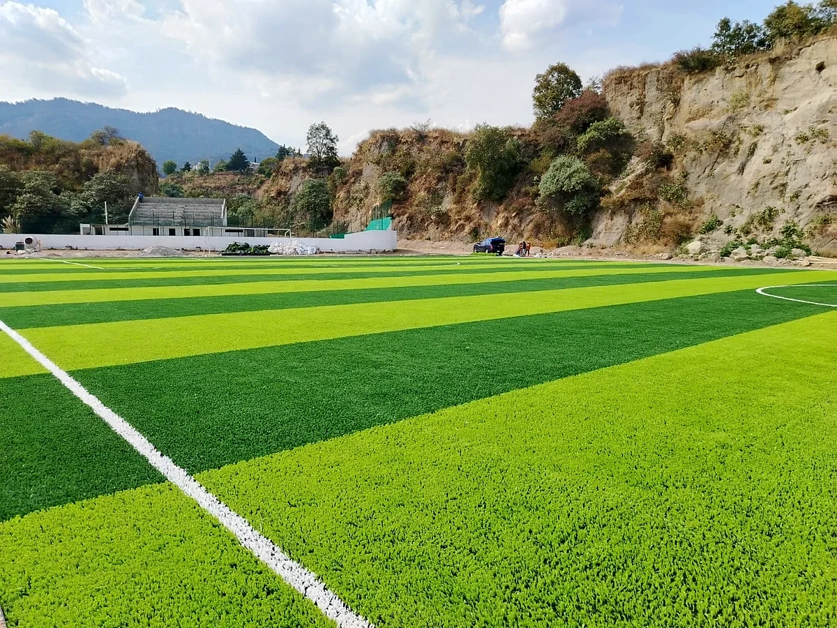 Cancha de fútbol soccer con pasto sintético en Tecnológico de Estudios Superiores de Huixquilucan, Estado de México: la cancha desdel fondo