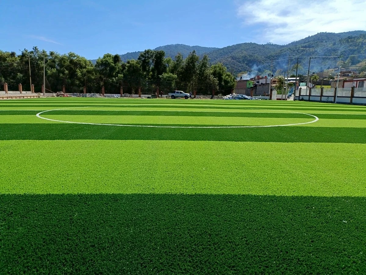 Cancha de fútbol soccer con pasto sintético en Unidad Deportiva de Almoloya, Almoloya de Alquisiras, Estado de México: la cancha desde la línea lateral