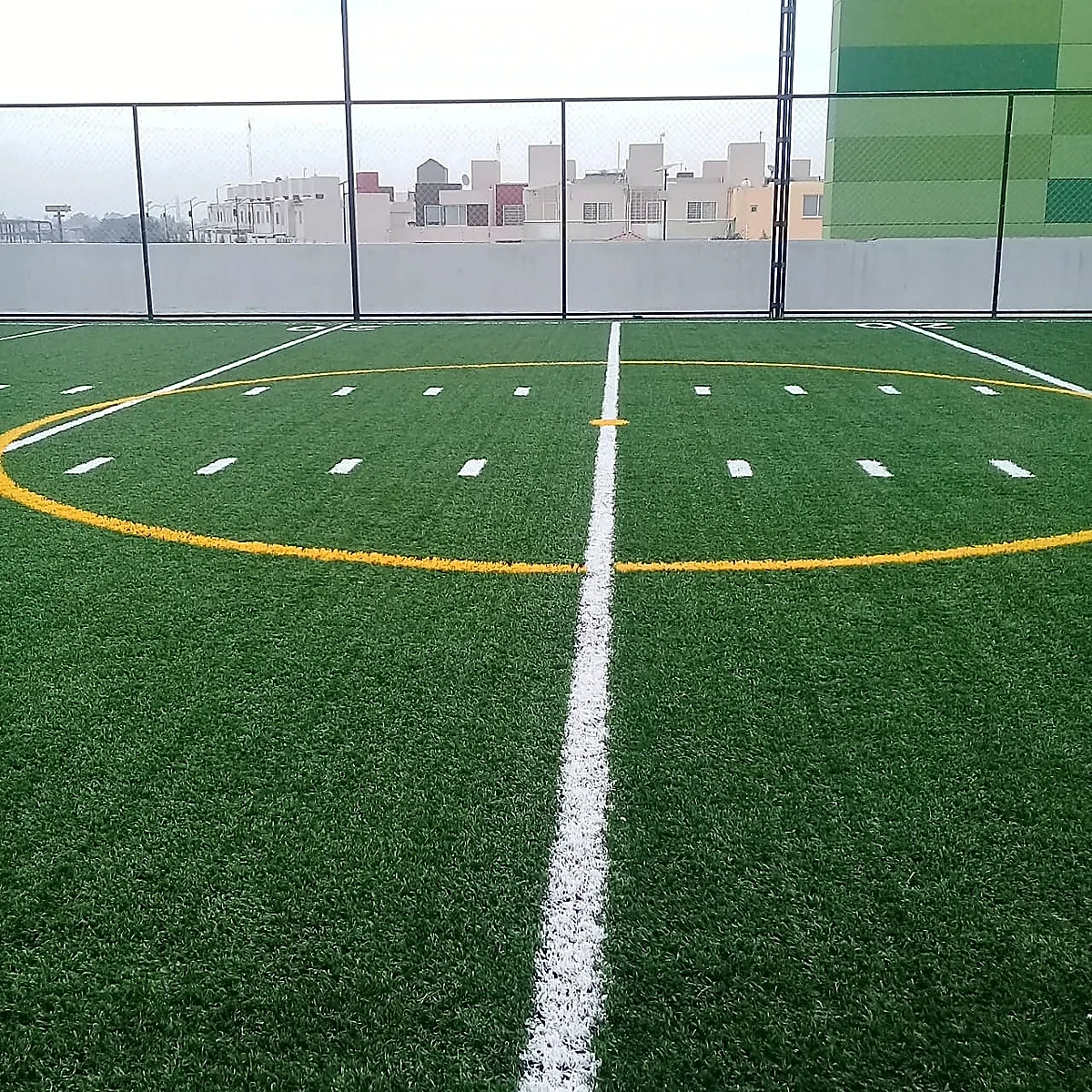 Cancha de tochito con pasto sintético en Plaza Estrella, Ecatepec, Estado de México: la cancha desde la línea lateral