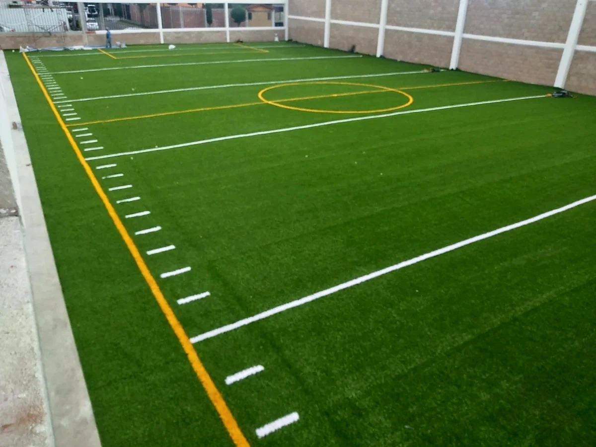 Cancha de tochito con pasto sintético en Tecámac, Estado de México: yardas y números insertados en el pasto