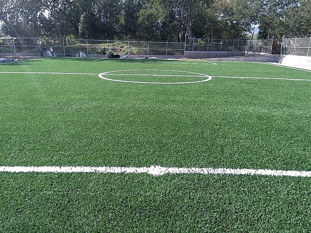 Cancha de fútbol 5 con pasto sintético en Campo Deportivo de Santa Cruz, Tixtla, Guerrero: la cancha desdel fondo
