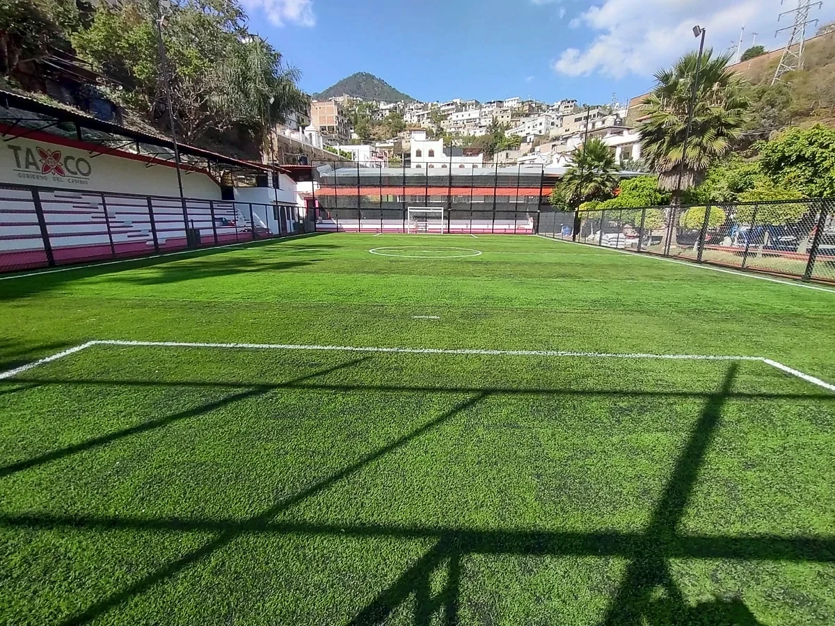 Cancha de fútbol 5 con pasto sintético en Parque Deportivo Pedro Martín, Taxco, Guerrero: la cancha desde la línea lateral
