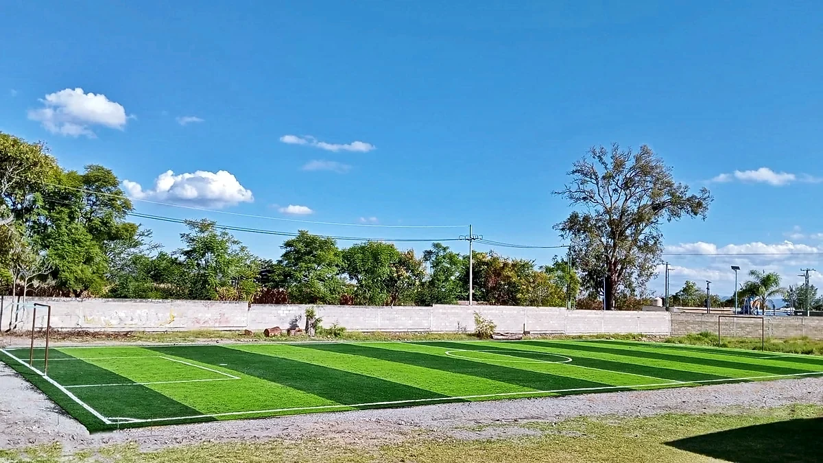 Cancha de fútbol 7 con pasto sintético en Escuela Secundaria Técnica Jesús Arizmendi Rogel, Pilcaya, Guerrero: líneas de juego insertadas en el mismo pasto