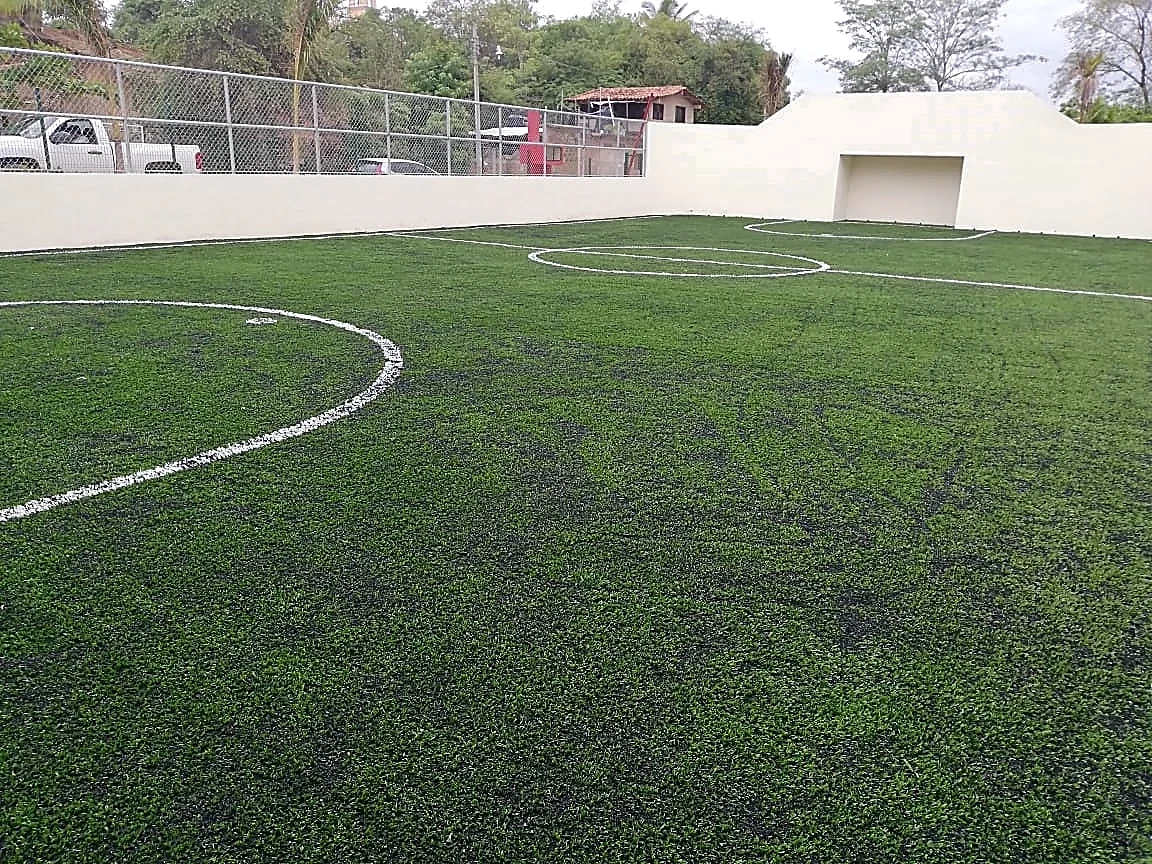 Cancha de fútbol rápido con pasto sintético en Cancha la Villa, San Luis Acatlán, Guerrero: líneas de juego insertadas en el pasto