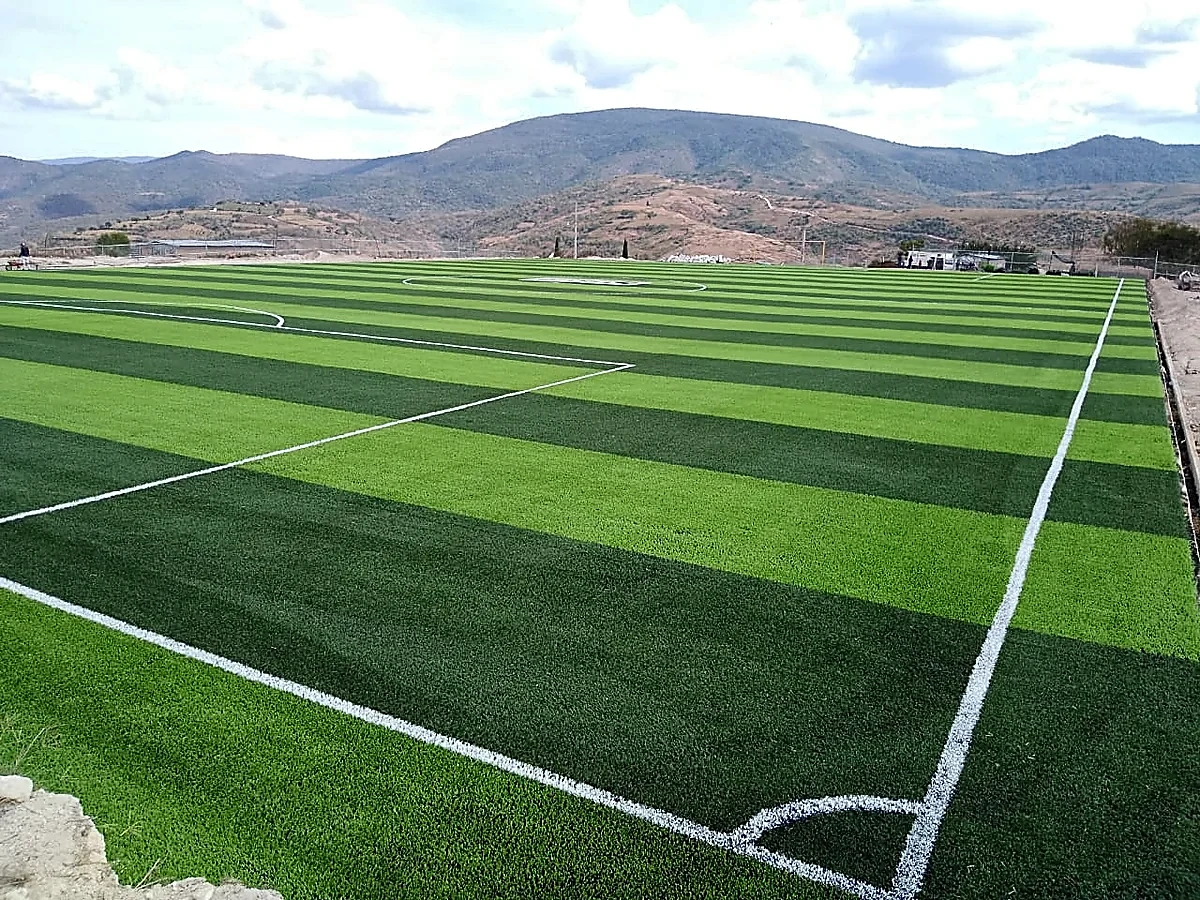 Cancha de fútbol soccer con pasto sintético en Unidad Deportiva de Tixtla, Tixtla (Atliaca), Guerrero: líneas de juego insertadas en el pasto