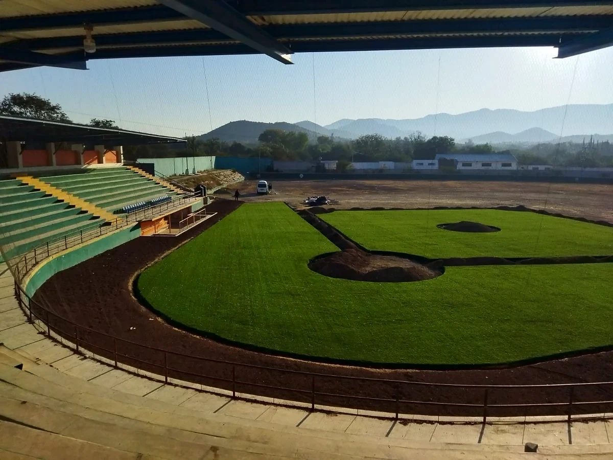 Instalación del pasto sintético del campo de béisbol en el Estadio Mineros de Zimapán: cuadro extendido y arcilla por nivelar