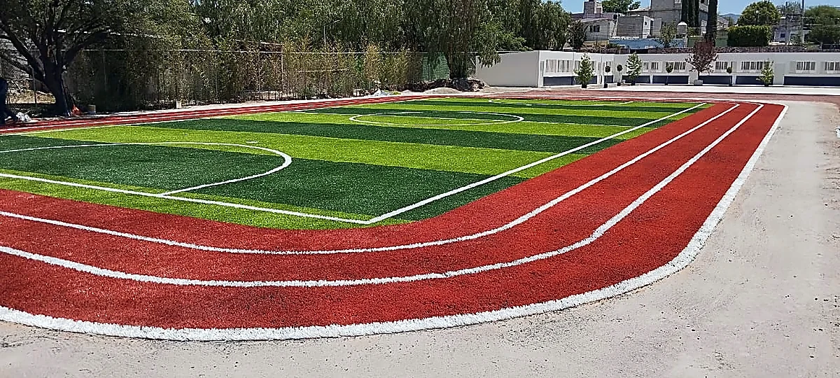 Cancha de fútbol 5 con pasto sintético en Colegio Jean Piaget de Actopan, Hidalgo: la cancha desdel fondo