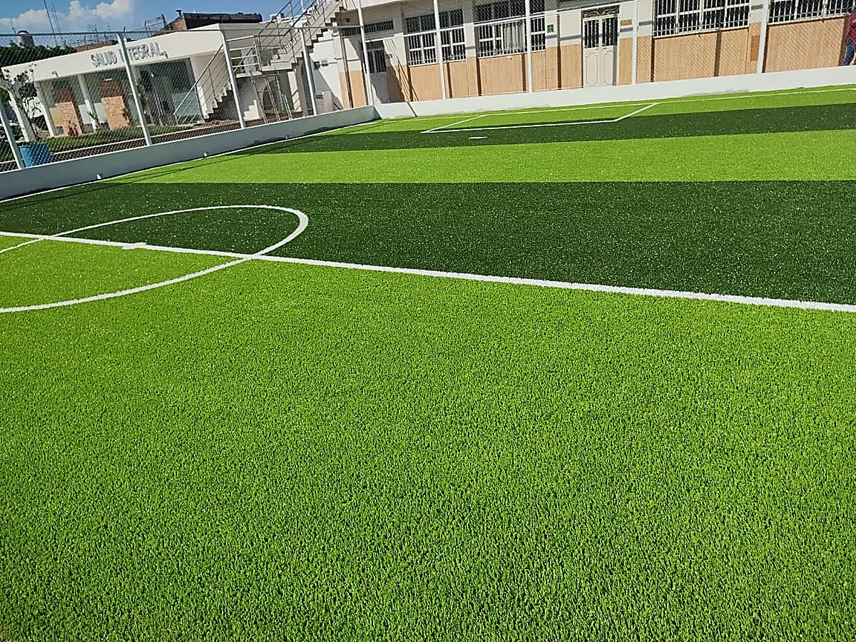 Cancha de fútbol 7 con pasto sintético en Colegio México Franciscano, Ciudad Guzmán, Jalisco: la cancha desde la línea lateral