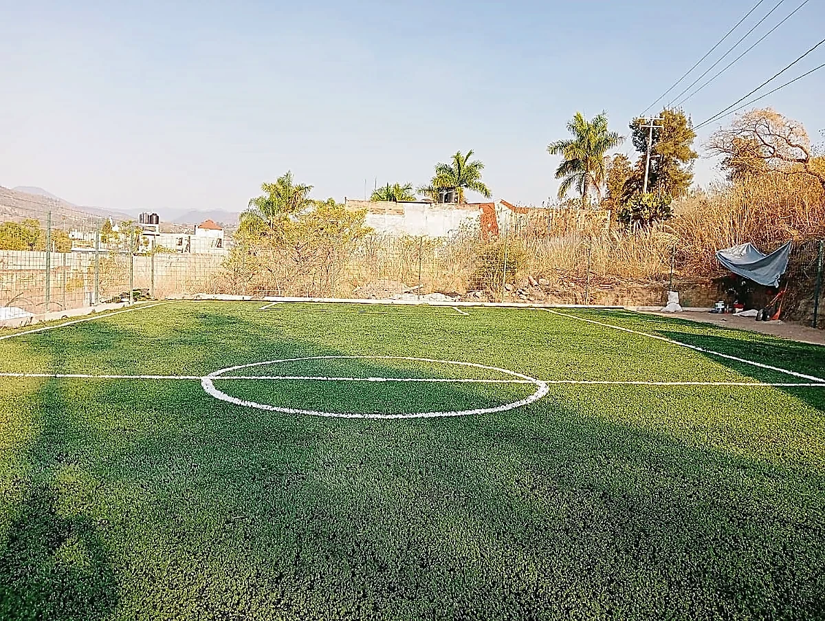 Cancha de fútbol 5 con pasto sintético en Escuela de Futbol Fénix, Zinapécuaro, Michoacán: otra vista de la cancha