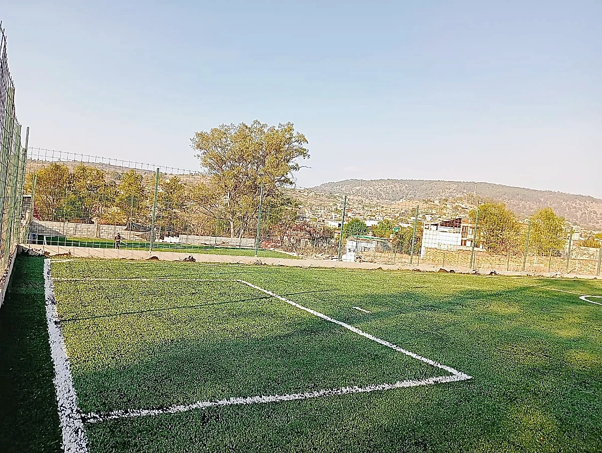 Cancha de fútbol 5 con pasto sintético en Escuela de Futbol Fénix, Zinapécuaro, Michoacán: pasto sintético deportivo recién cepillado
