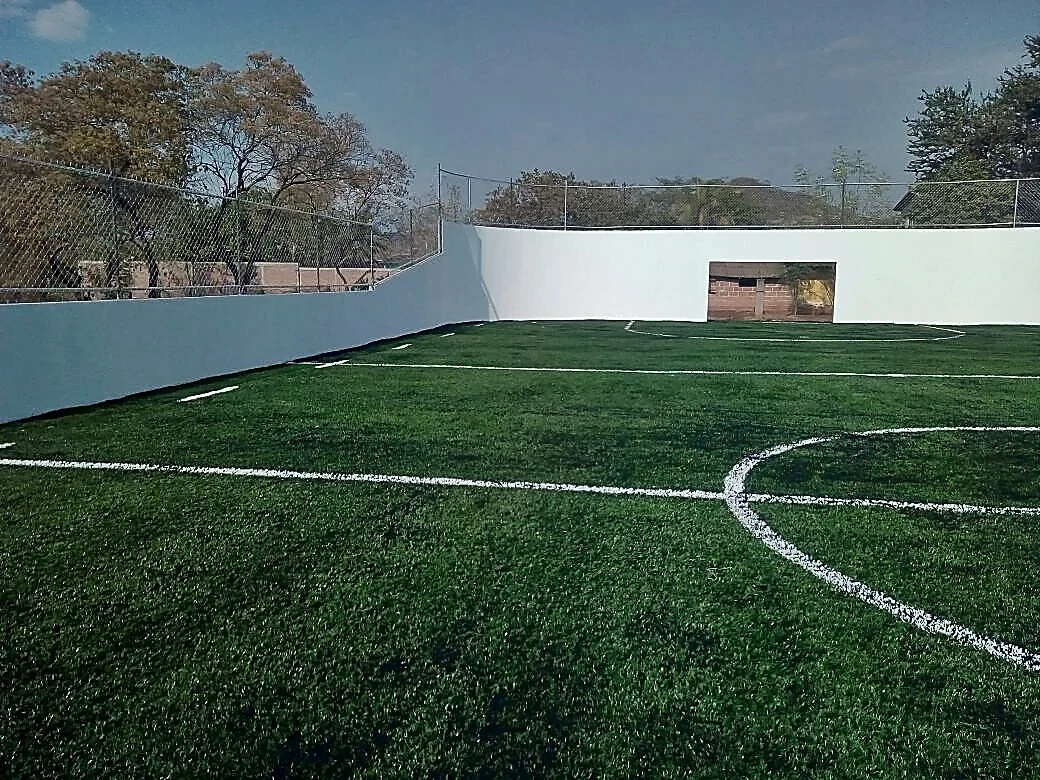 Cancha de fútbol 5 con pasto sintético en Unidad Deportiva Melchor Ocampo, Tuzantla, Michoacán: la cancha desde la línea lateral