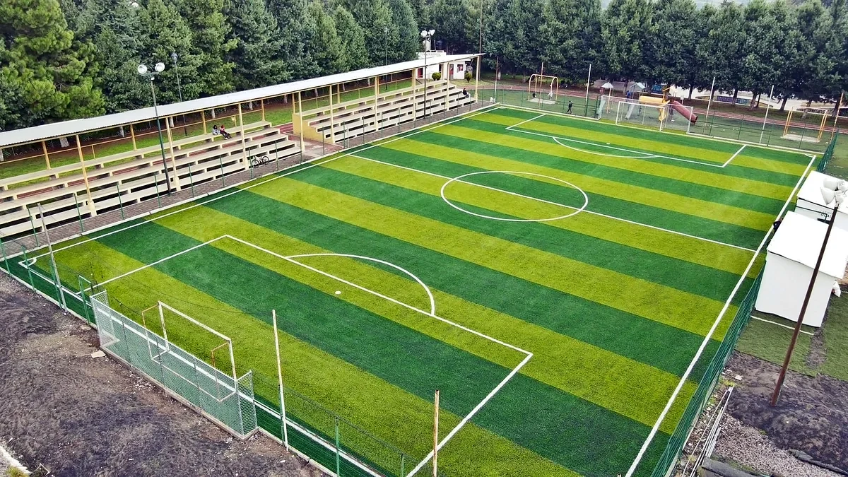 Cancha de fútbol 7 con pasto sintético en Complejo Deportivo Santa Clara del Cobre, Michoacán: líneas de juego insertadas en el mismo pasto