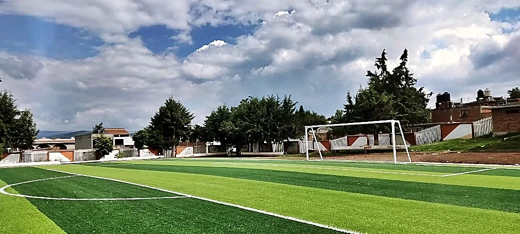 Cancha de fútbol soccer con pasto sintético en Unidad Deportiva 18 de Marzo, Tzintzingareo (Irimbo), Michoacán: líneas de juego insertadas en el pasto