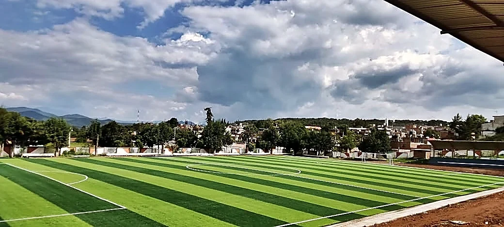 Cancha de fútbol soccer con pasto sintético en Unidad Deportiva 18 de Marzo, Tzintzingareo (Irimbo), Michoacán: pasto sintético deportivo recién cepillado