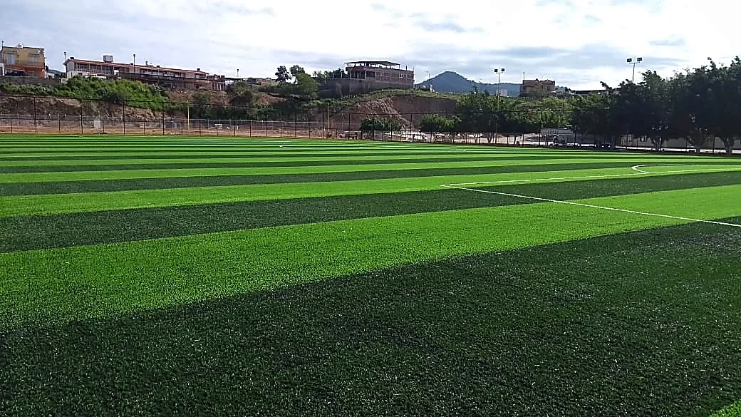 Cancha de fútbol soccer con pasto sintético en Unidad Deportiva Arteaga, cancha 1, Michoacán: la cancha desde la línea lateral