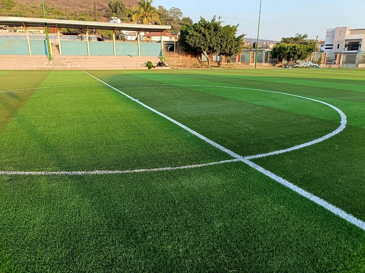 Cancha de fútbol soccer con pasto sintético en Unidad Deportiva Juárez, Benito Juárez, Michoacán: líneas de juego insertadas en el pasto