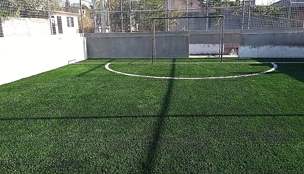 Cancha de fútbol 5 con pasto sintético en Unidad Deportiva 1ra Seccion, Xochitepec, Morelos: la cancha desde la línea lateral