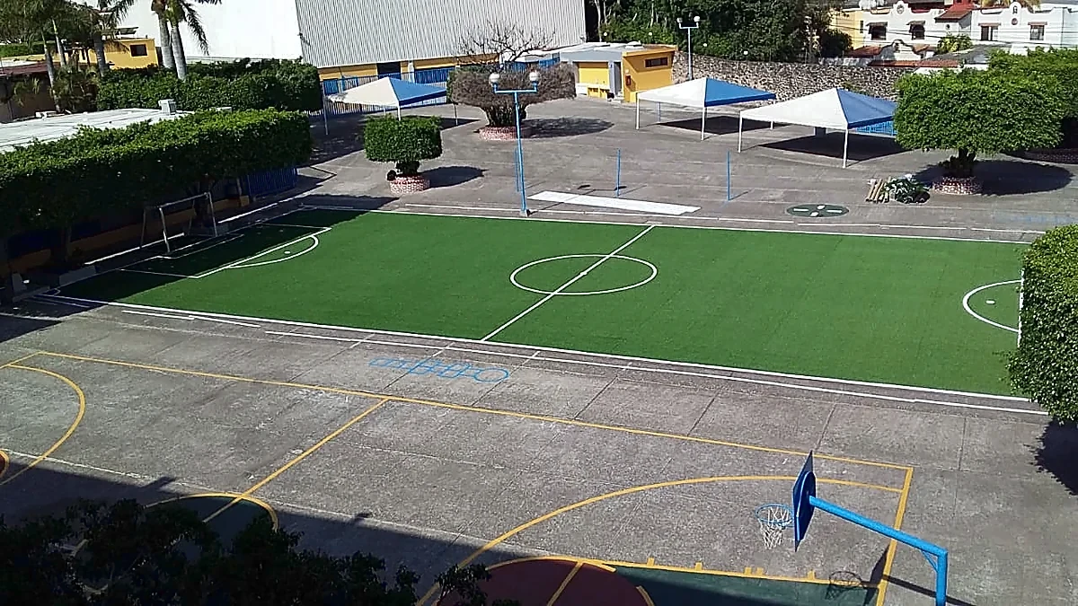 Cancha de fútbol 7 con pasto sintético en Colegio Miraflores, Cuernavaca, Morelos: la cancha desde la línea lateral