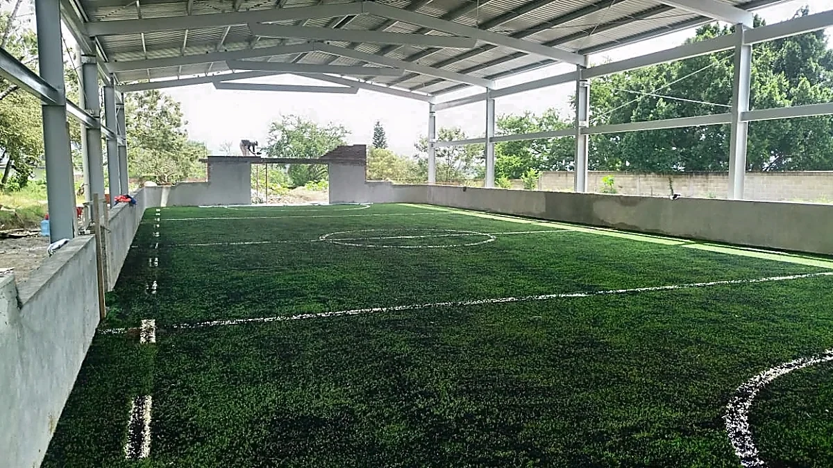 Cancha de fútbol rápido con pasto sintético en Escuela Primaria Patria Nueva, Xochitepec, Morelos: la cancha desde la línea lateral