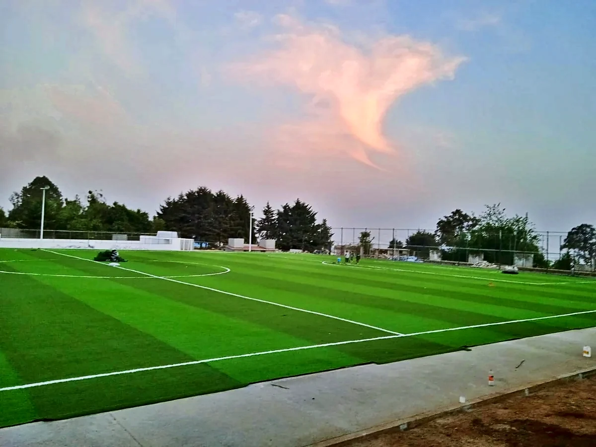 Cancha de fútbol soccer con pasto sintético en Unidad Deportiva Huitzilac, Morelos: la cancha desdel fondo