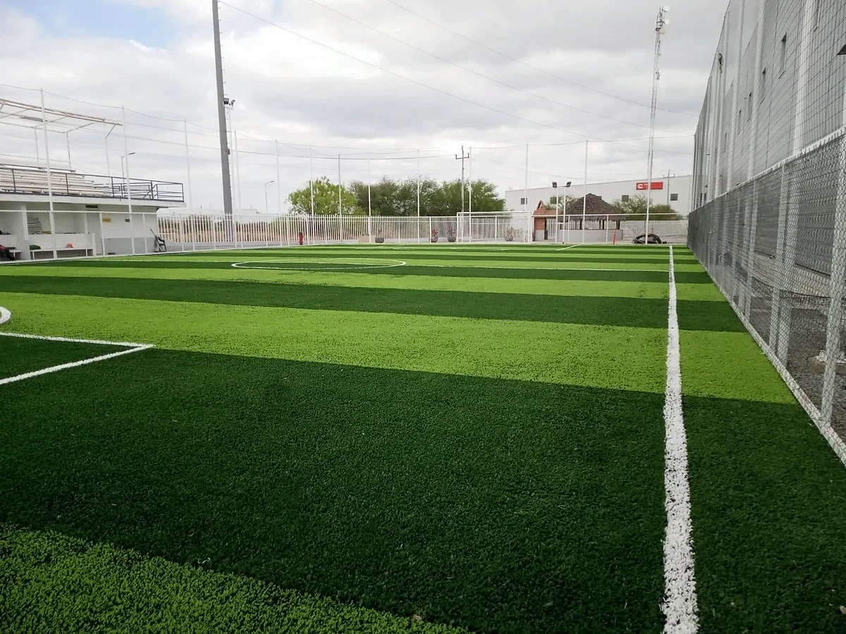 Cancha de fútbol 7 con pasto sintético en Ciénega de Flores, Nuevo León: pasto sintético deportivo recién cepillado