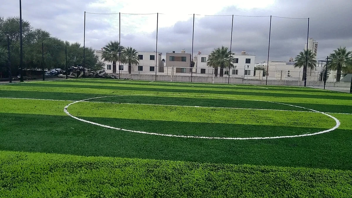 Cancha de fútbol 7 con pasto sintético en Corporativo BANREGIO, San Nicolás de los Garza, Nuevo León: la cancha desde la línea lateral