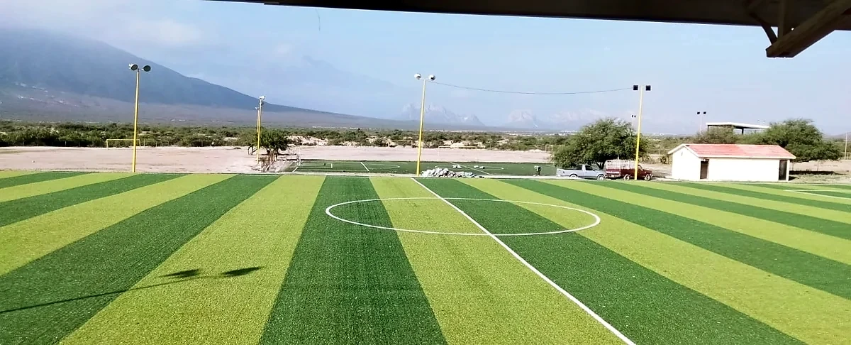Cancha de fútbol soccer con pasto sintético en Mina, Nuevo León: la cancha desde la línea lateral