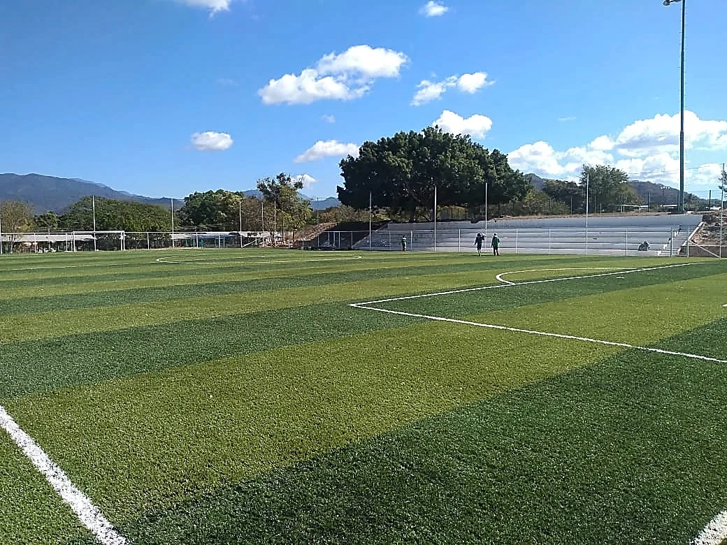Cancha de fútbol 7 con pasto sintético en Unidad Deportiva Santa Maria Huatulco, Oaxaca: la cancha desde la línea lateral